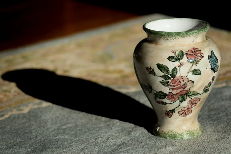 Ilustrasi mimpi barang antik — a vase sitting on top of a rug on a floor