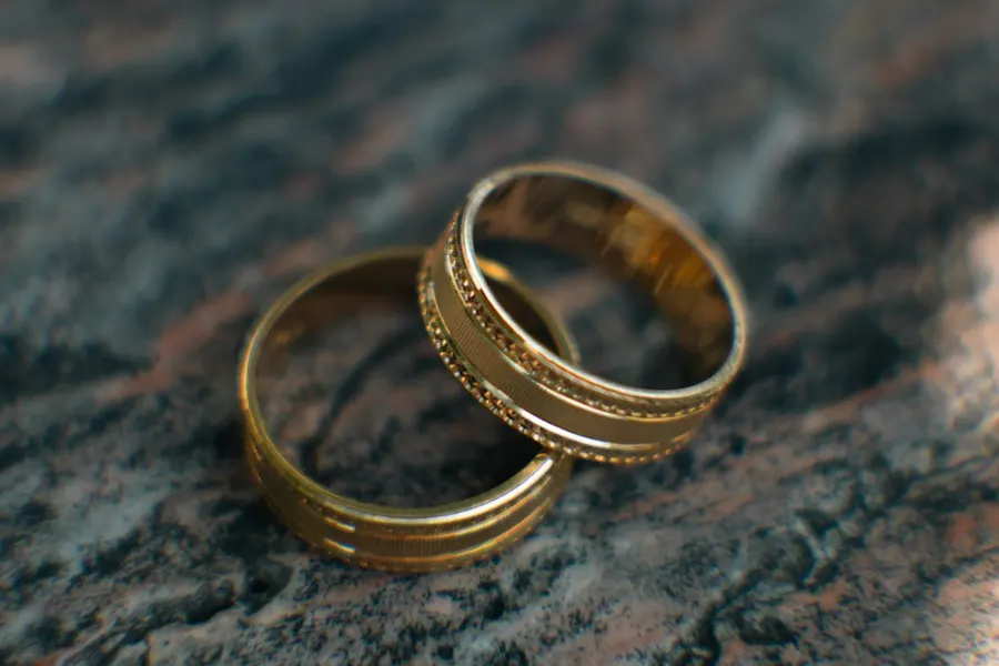 Ilustrasi mimpi istri selingkuh — Two gold wedding rings sitting on top of a table