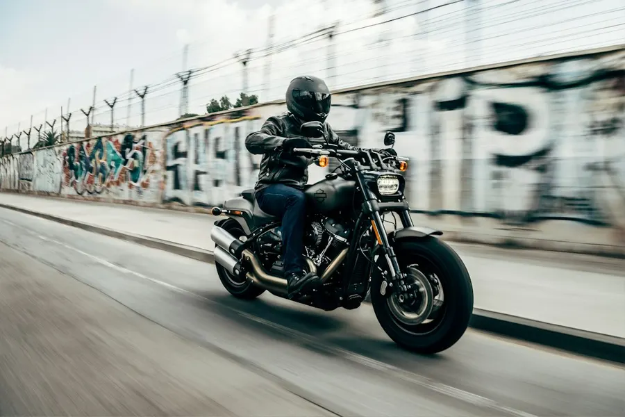 Ilustrasi mimpi jatuh dari motor — person riding motorcycle on concrete road