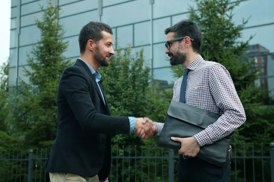 Ilustrasi mimpi ketemu presiden — Two businessmen shaking hands outside modern building