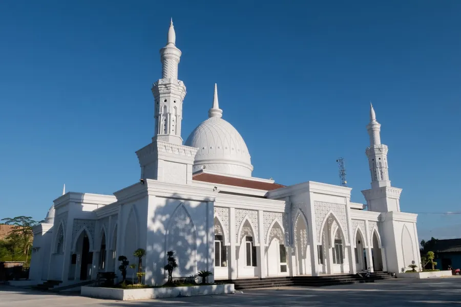 Ilustrasi mimpi masjid — a large white building with two towers and a dome