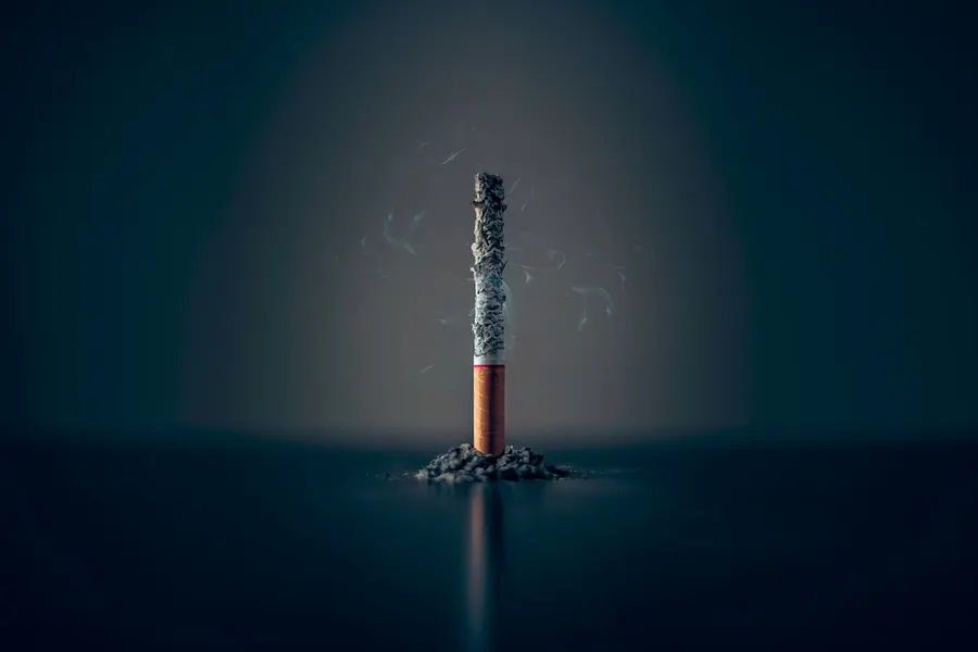 Ilustrasi mimpi merokok — single cigarette stick with ashes stick
