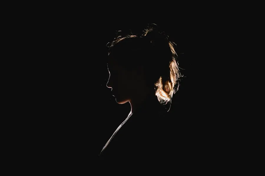 Ilustrasi mimpi tuyul — a black silhouette of a woman