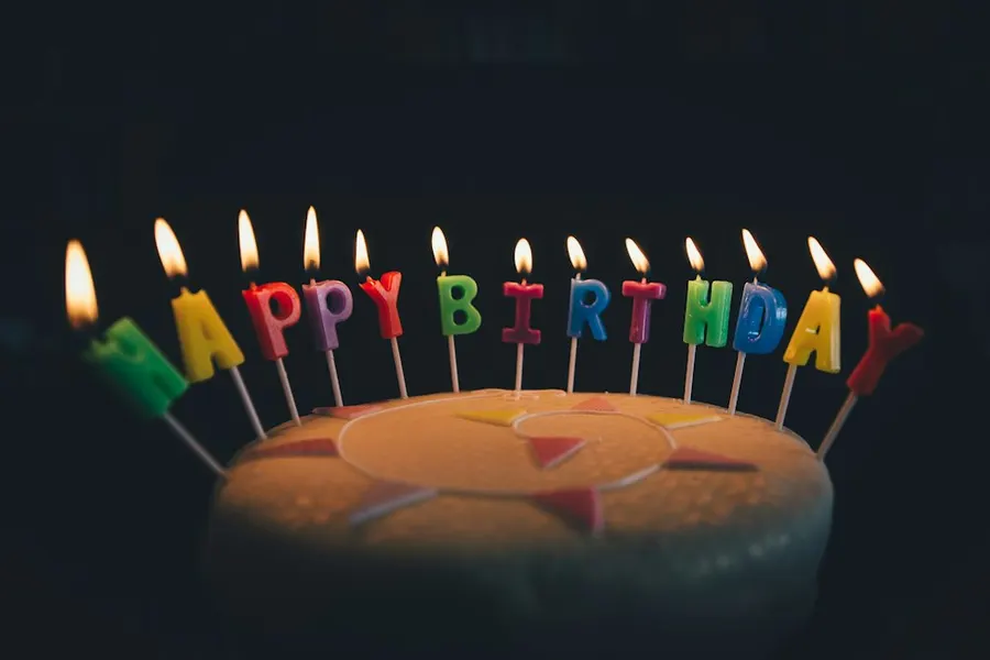 Ilustrasi mimpi ulang tahun — round fondant cake with happy birthday candle